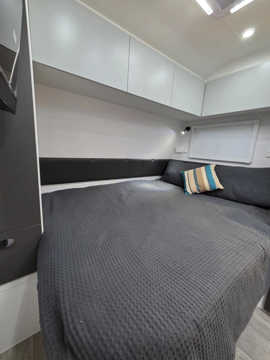 Safari Legacy 228 front bedroom with grey bedding and overhead cupboards