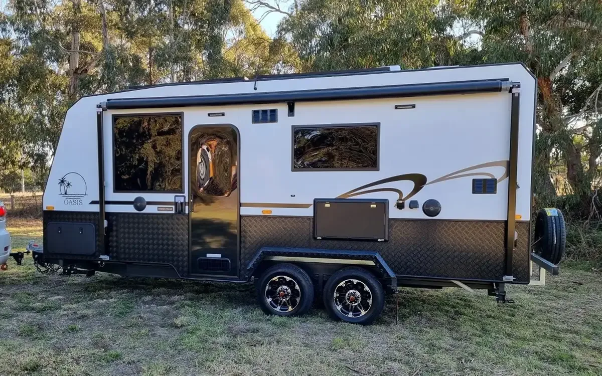 Safari Oasis 186 caravan, door side profile, parked on grass in front of gum trees