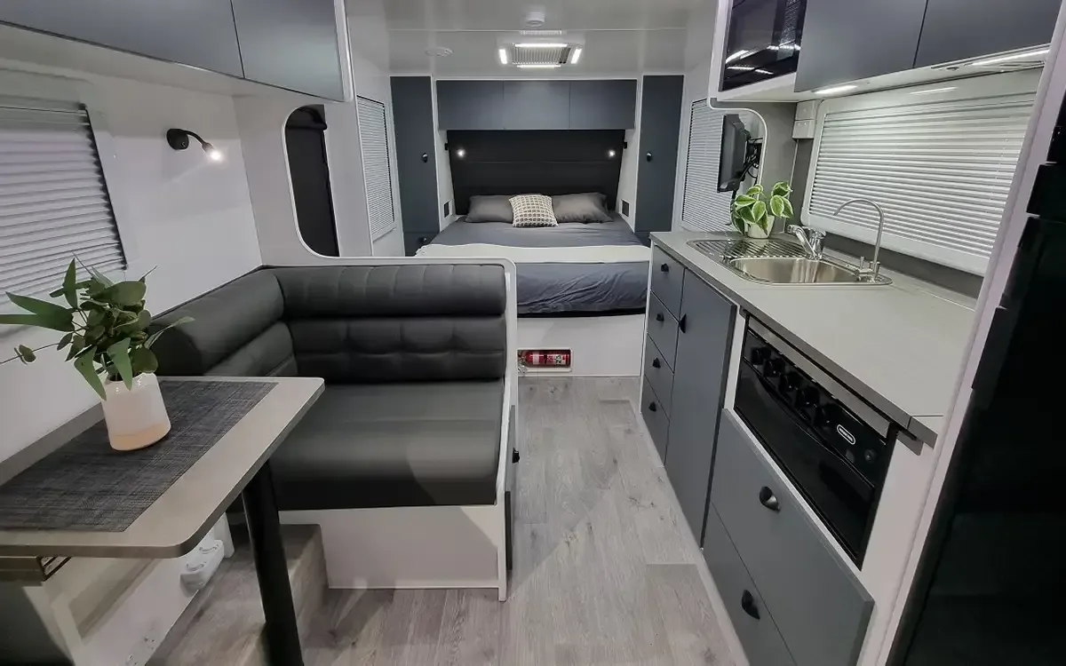 Safari Oasis 186 interior, L-lounge and table beside the kitchen, queen bed at the front