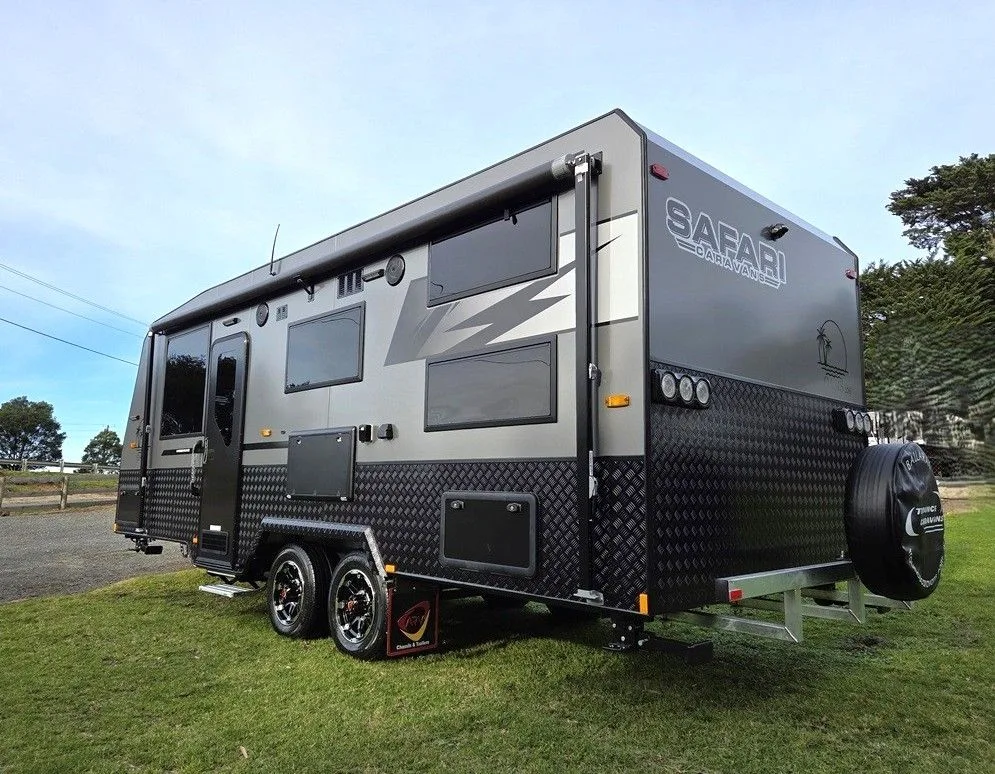 Safari Oasis caravan in grey, rear three-quarter view with spare wheel and checkerplate lower panels