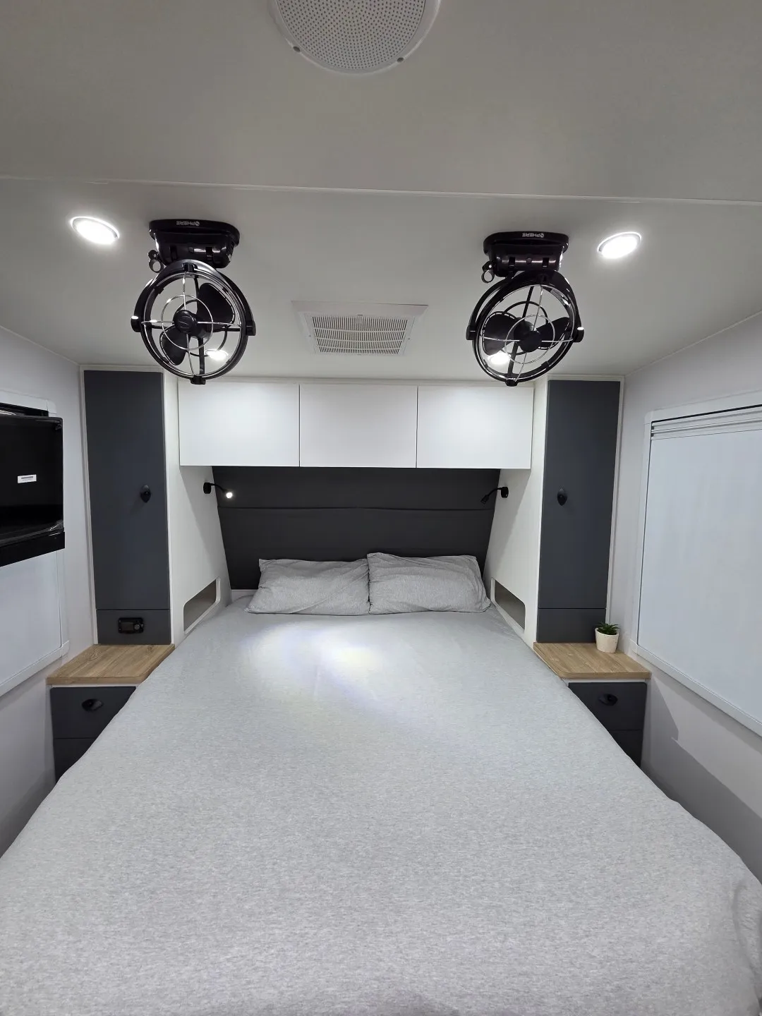 Queen bed with bedside cabinets and twin fans in a Safari X-Trak 216 KE