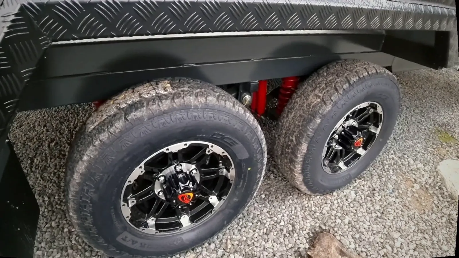 Tandem off-road wheels and red shock absorbers under a Safari chassis